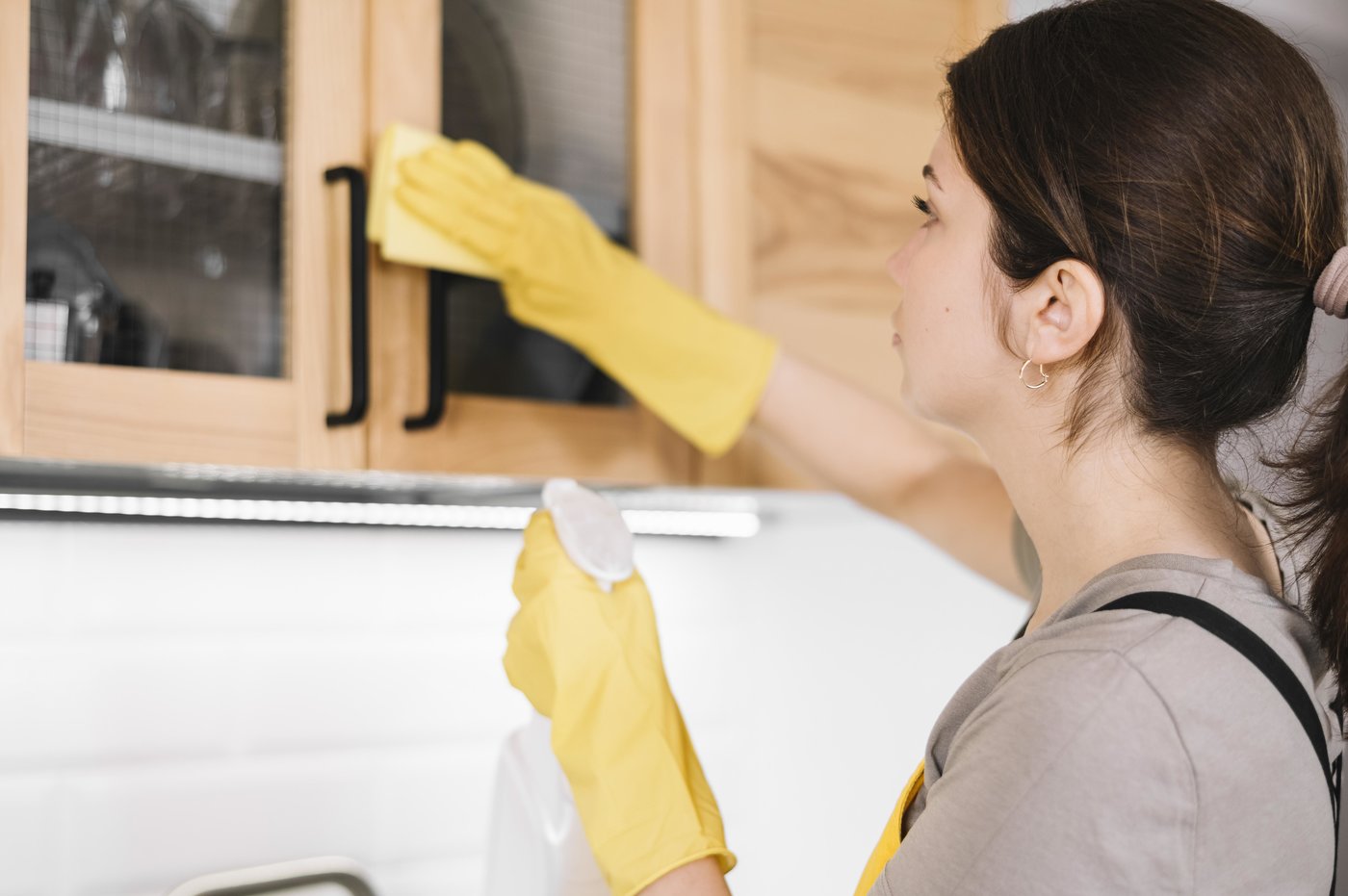 mulher limpando armário da cozinha