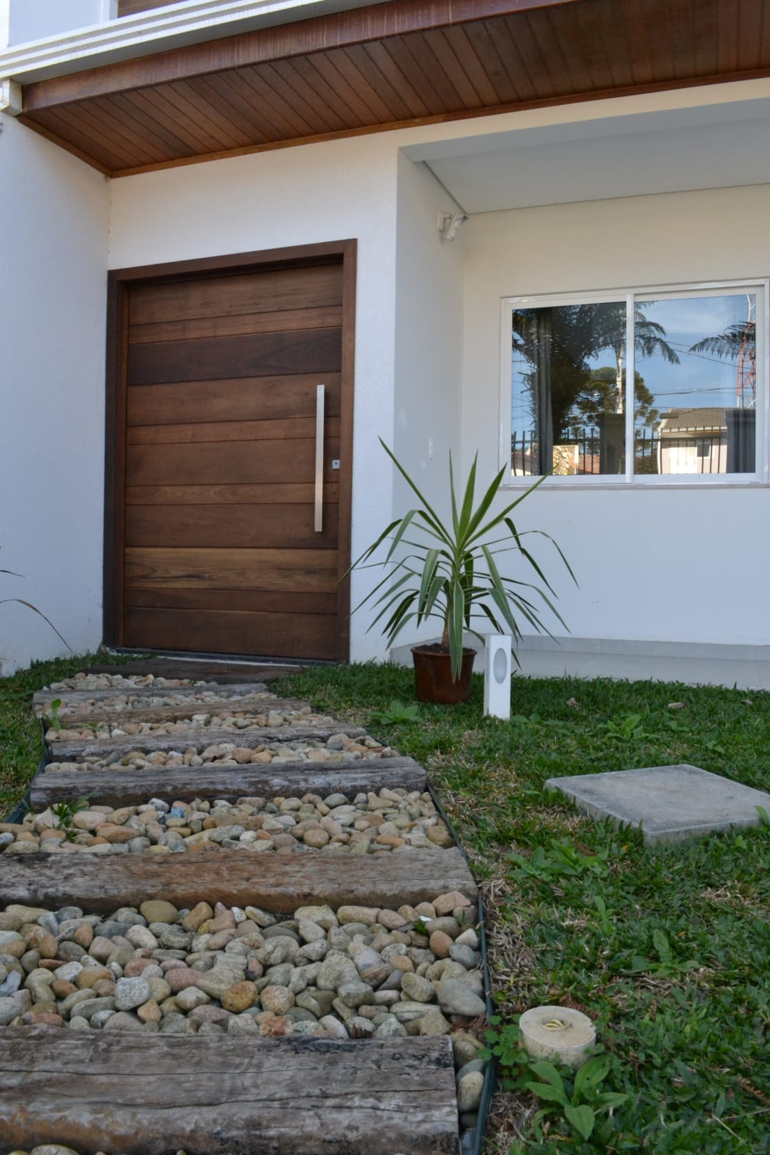 fachada com porta pivotante de madeira