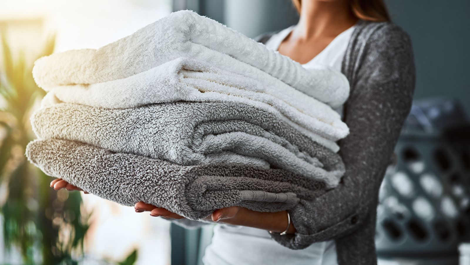 mulher segurando toalhas de banho