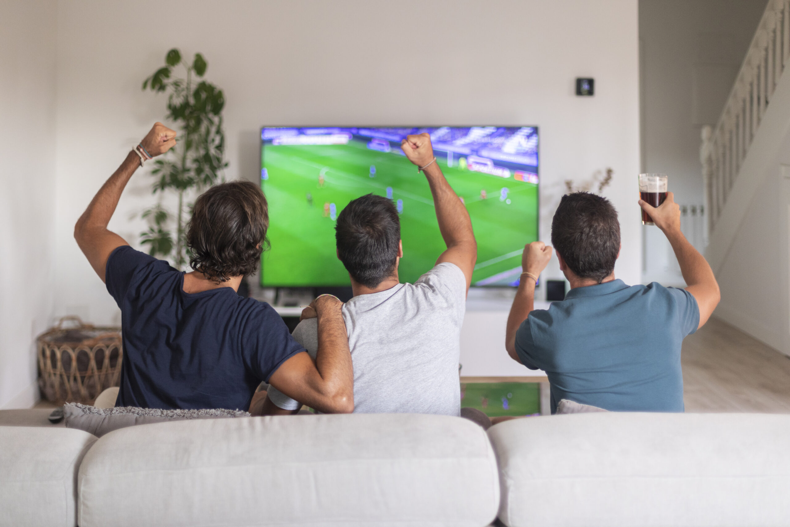 pessoas assistindo futebol na tv