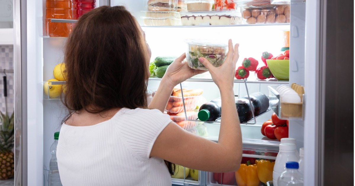 mulher guardando alimentos na geladeira