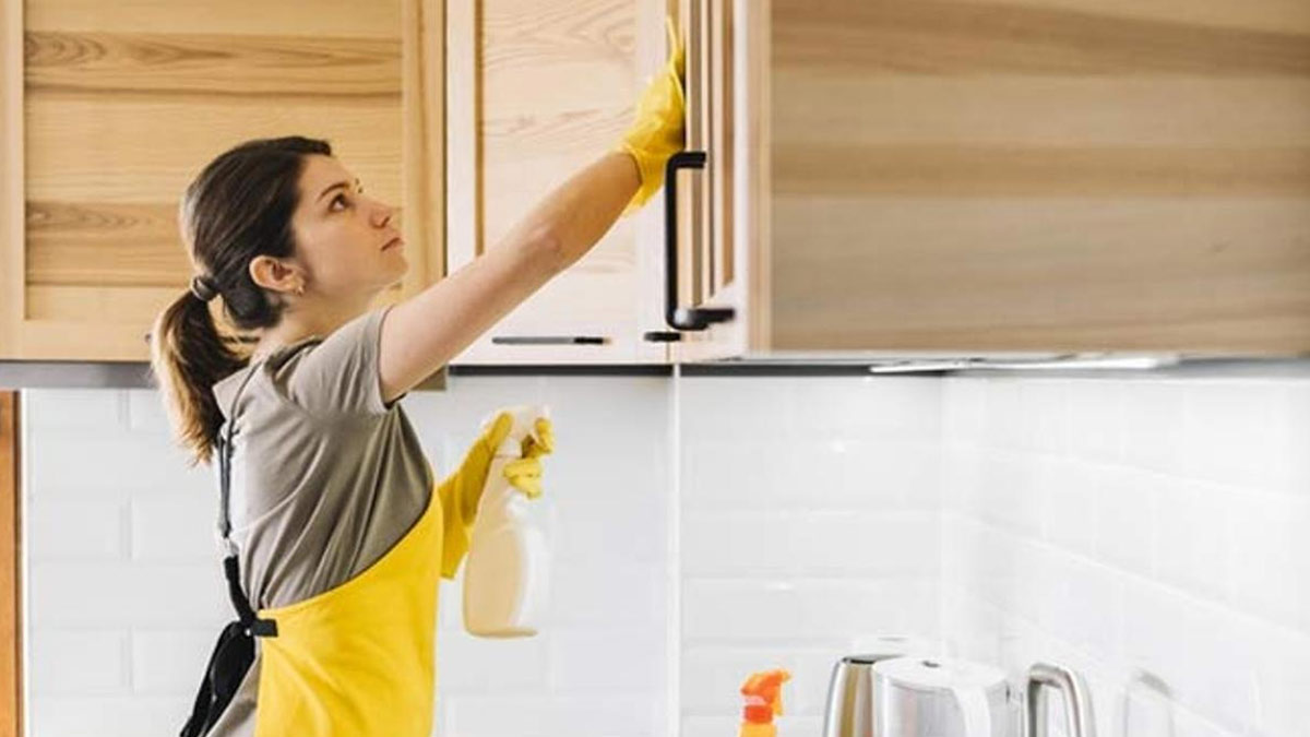 mulher limpando armário de cozinha