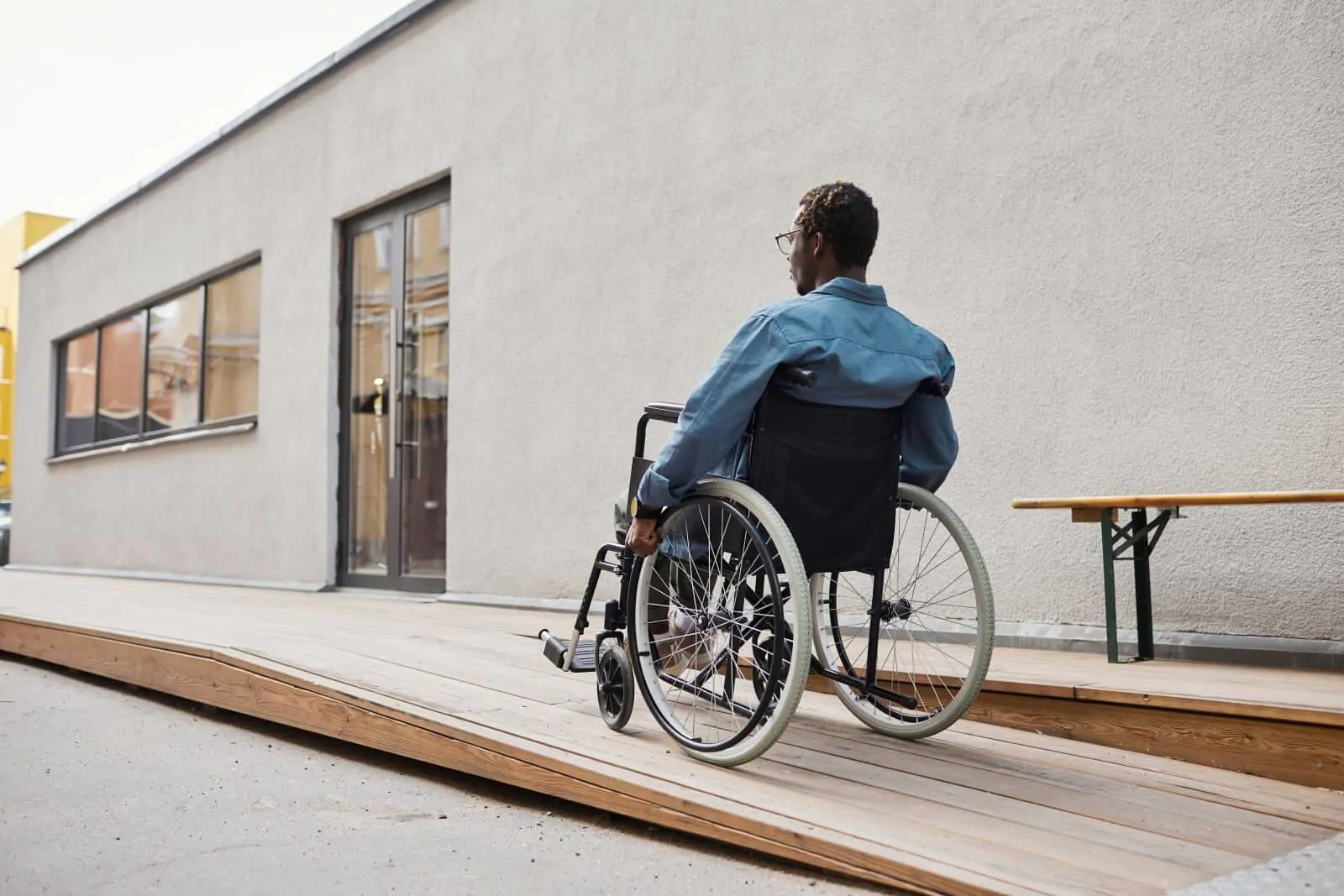 homem subindo rampa com cadeira de rodas