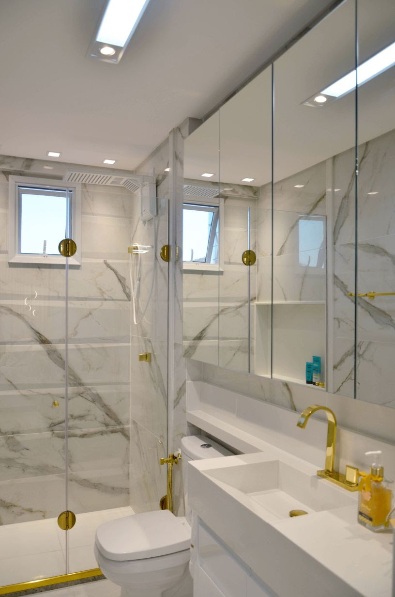 banheiro claro com detalhes em dourado