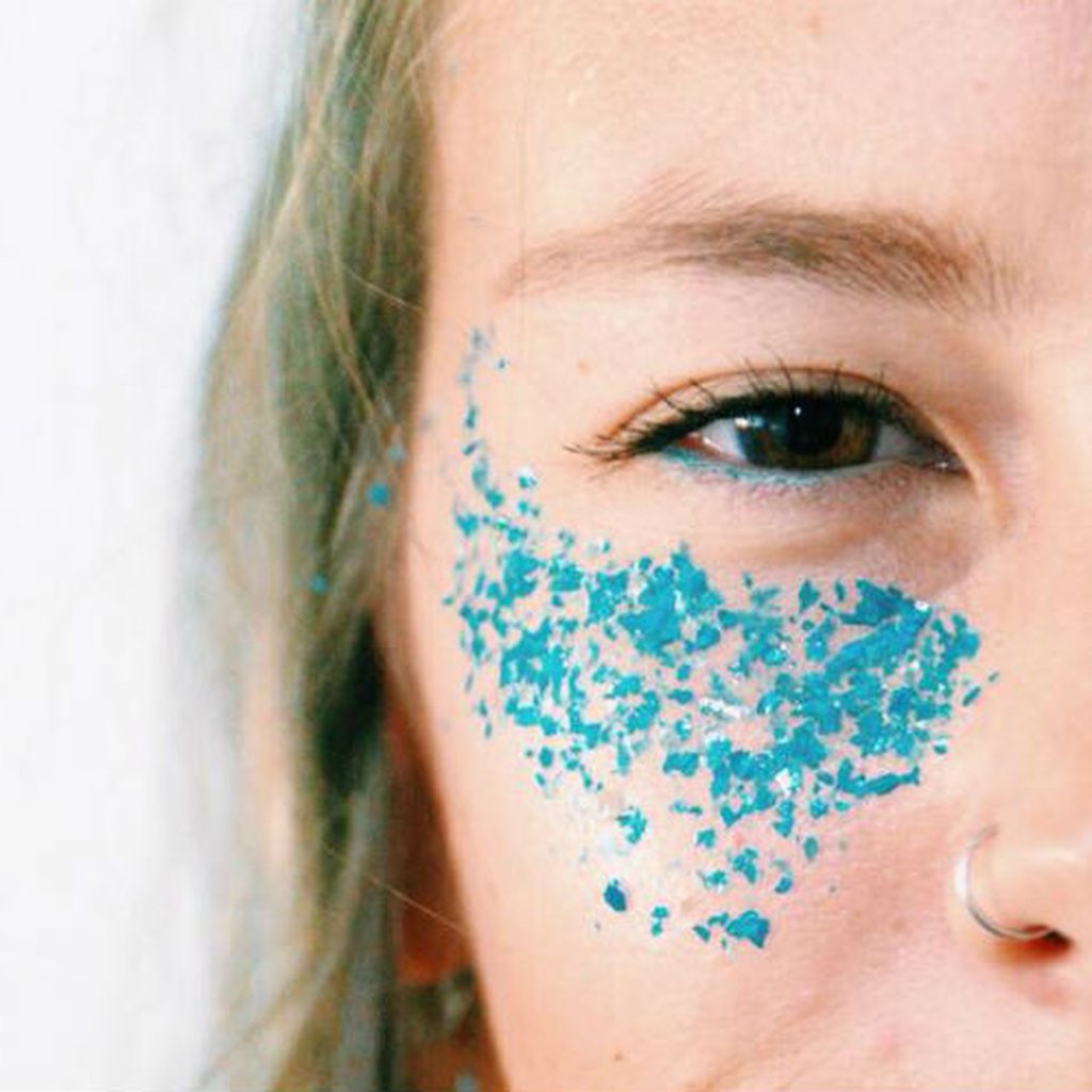 mulher com glitter ecológico azul em rosto