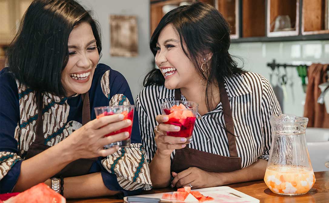 mulheres rindo com drink em mãos
