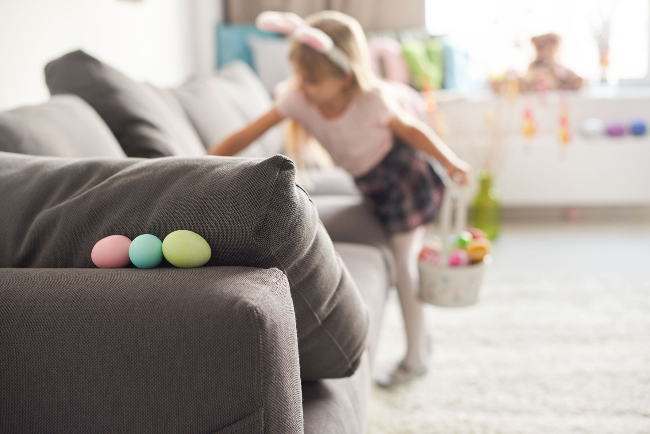 criança procurando ovos escondidos em sofá