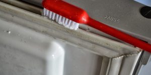 limpeza da borracha da geladeira com escova e pasta de dente