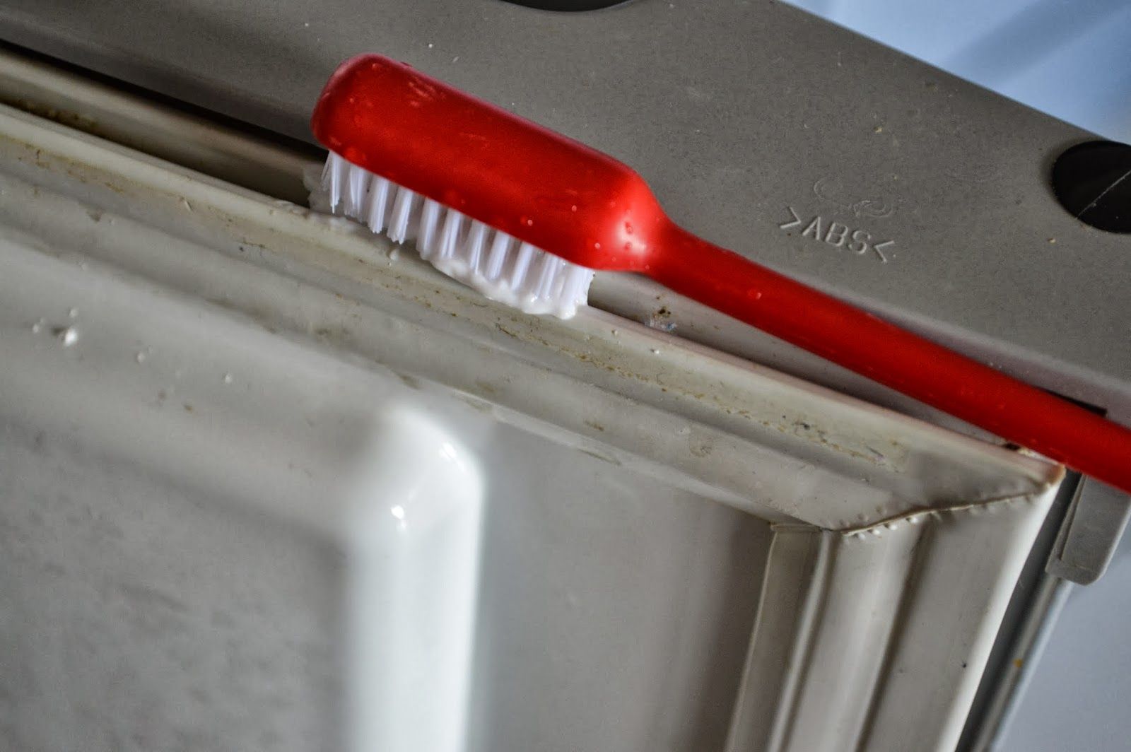 limpeza da borracha da geladeira com escova e pasta de dente