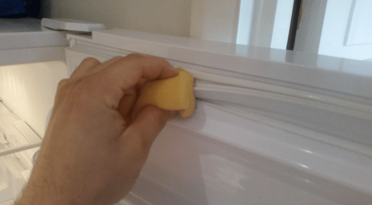 limpeza da borracha da geladeira com esponja