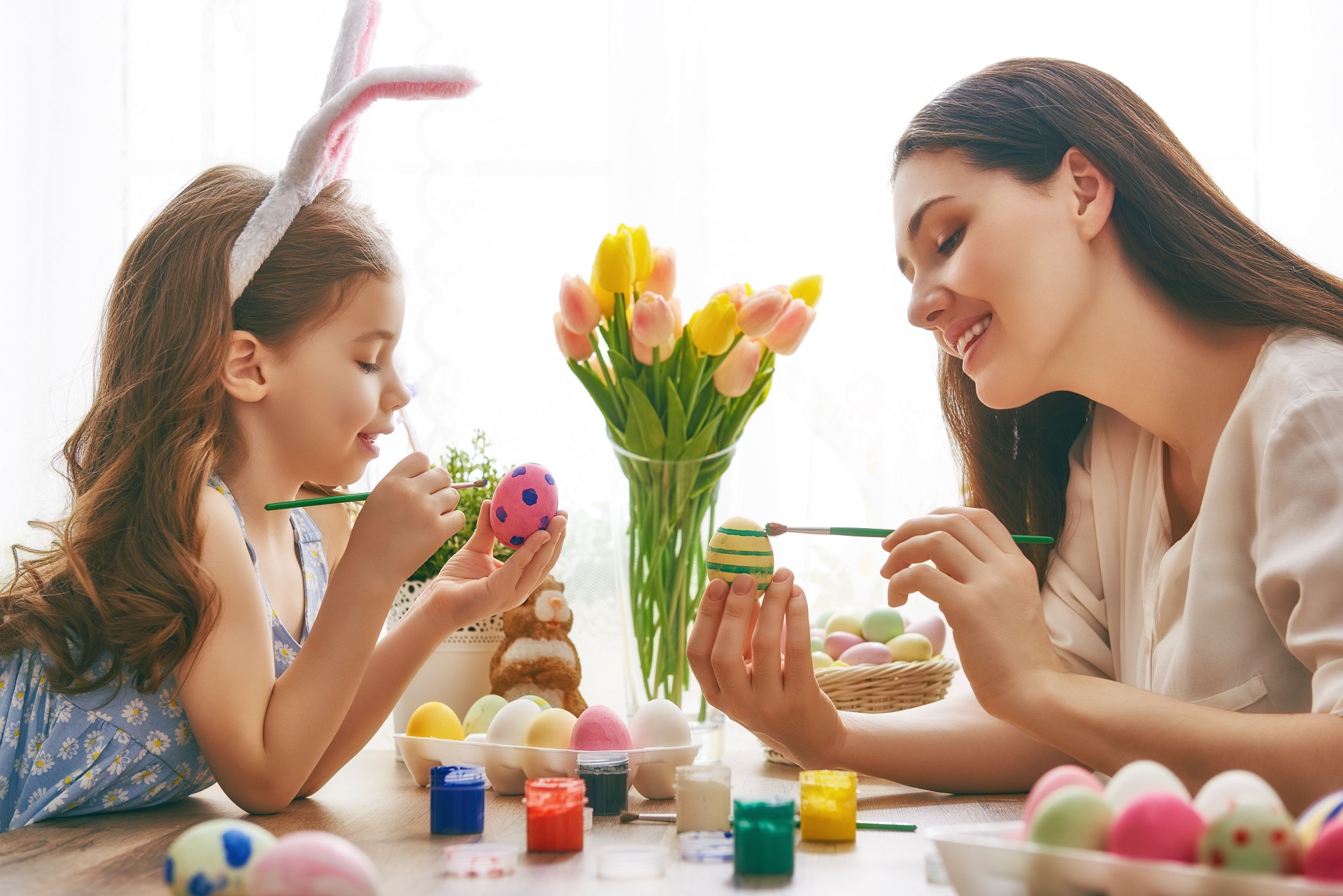 mãe e filha pintando ovos de páscoa