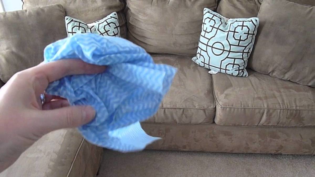 pessoa segurando pano de microfibra para limpar sofá