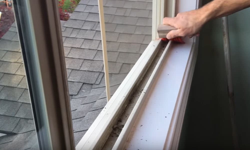 pessoa limpando trilho de janela
