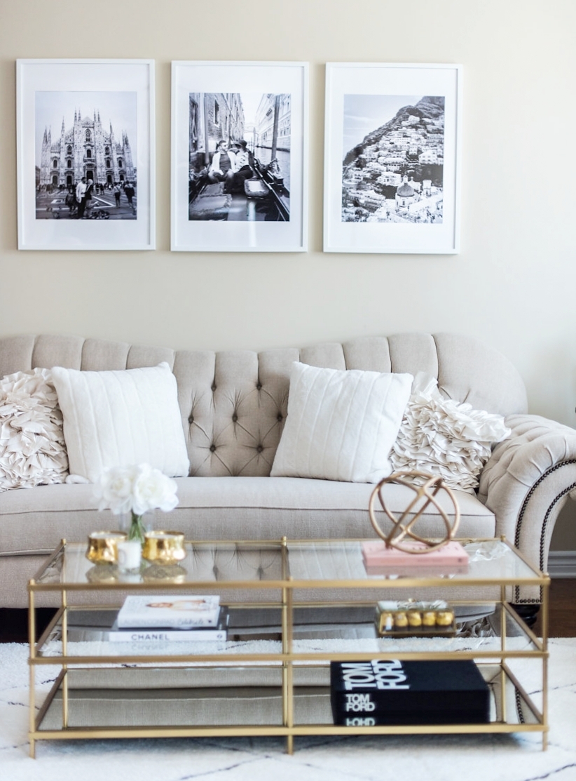 sala com sofá bege e mesa de centro com detalhes em dourado