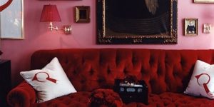 sala com sofá vermelho e parede rosa