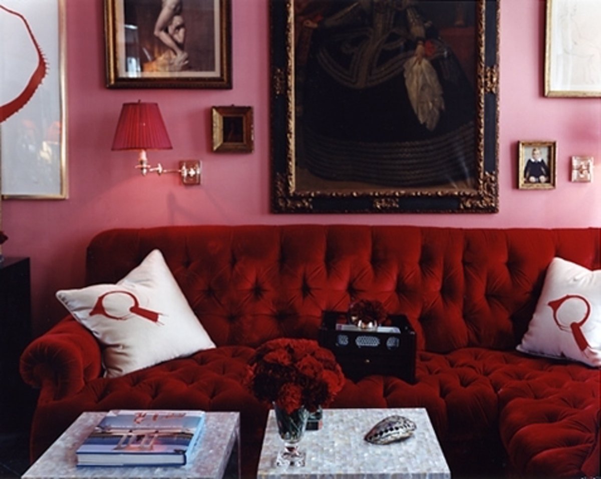 sala com sofá vermelho e parede rosa