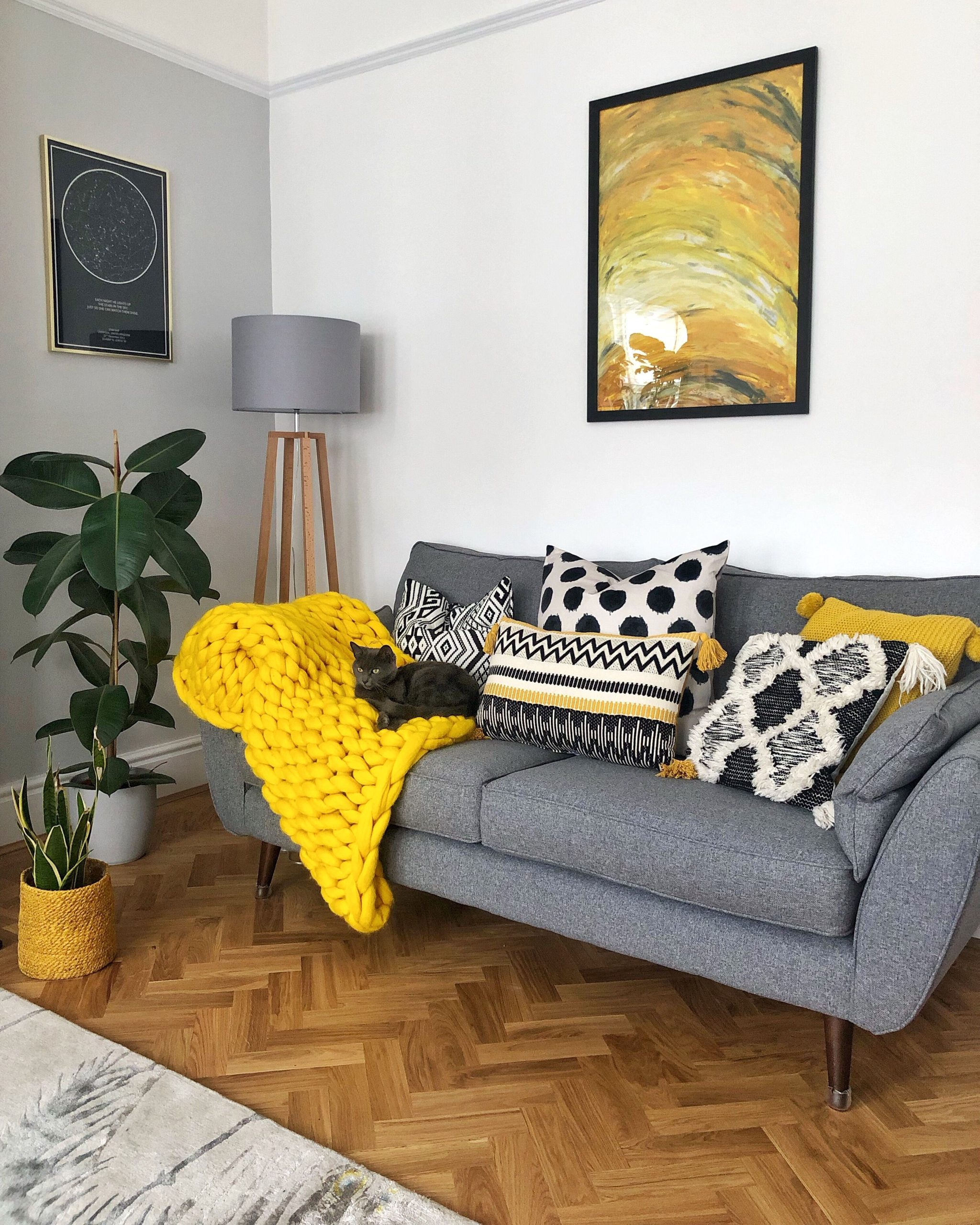 sala de estar com sofá cinza e detalhes em amarelo