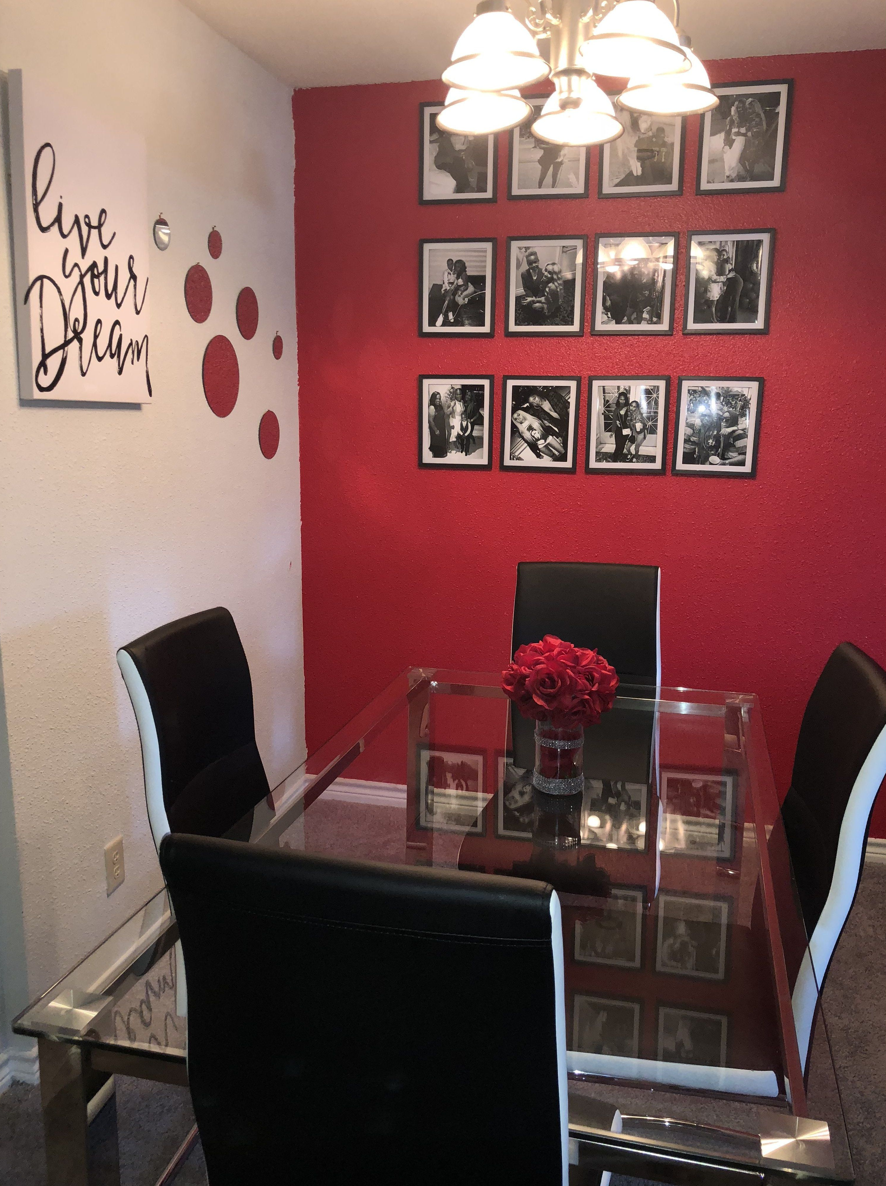sala de jantar com parede vermelha e cadeiras pretas