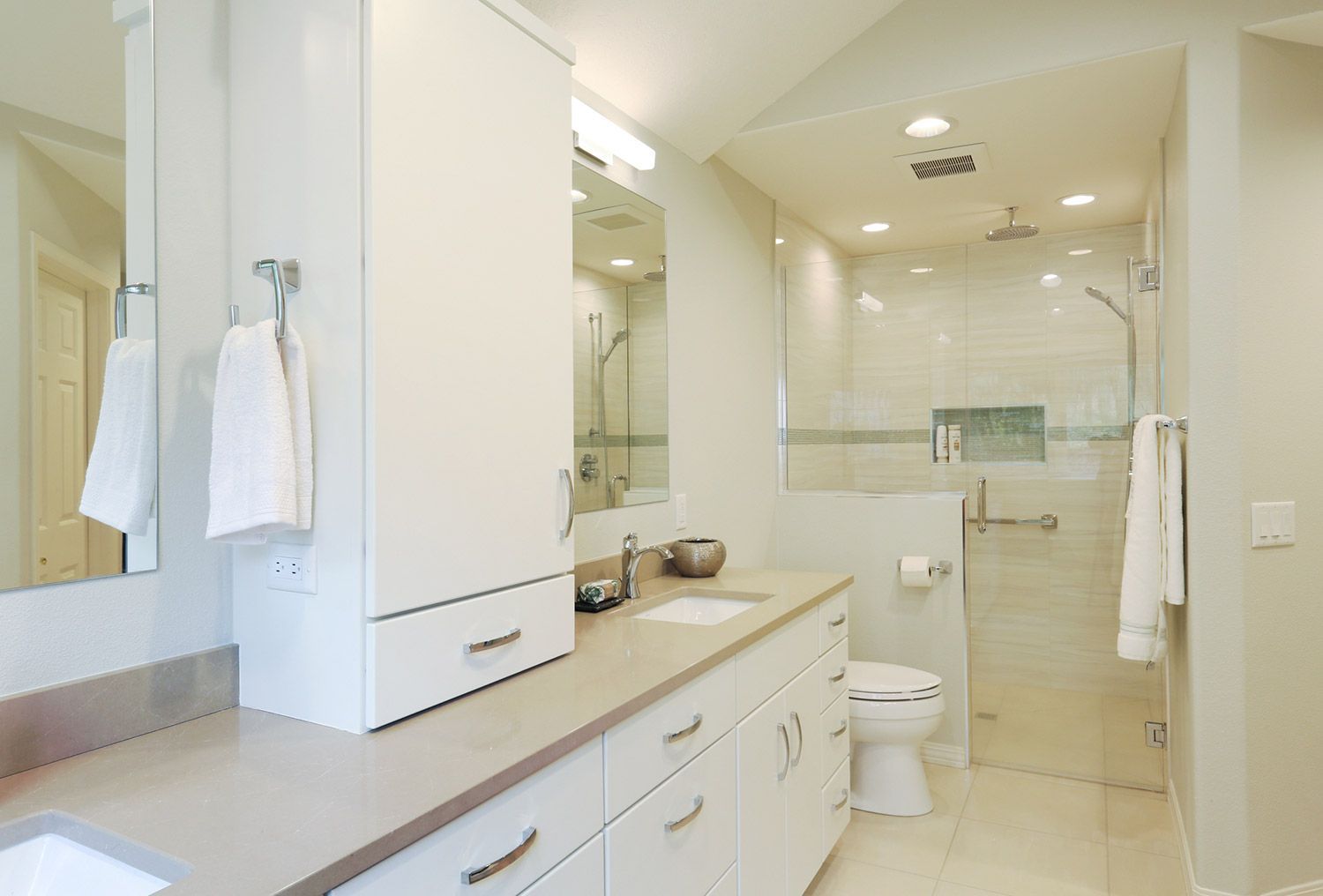 banheiro com gabinetes brancos