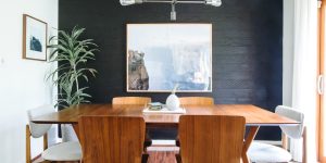 sala de jantar com móveis de madeira e parede preta