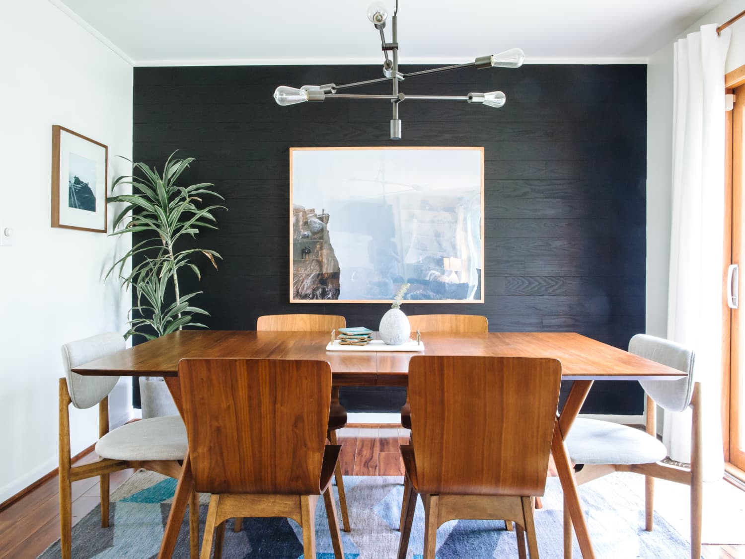 sala de jantar com móveis de madeira e parede preta
