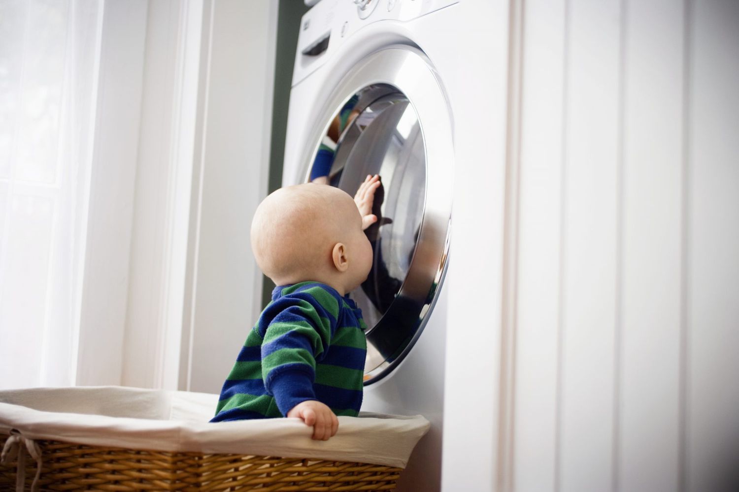bebê tocando na máquina de lavar