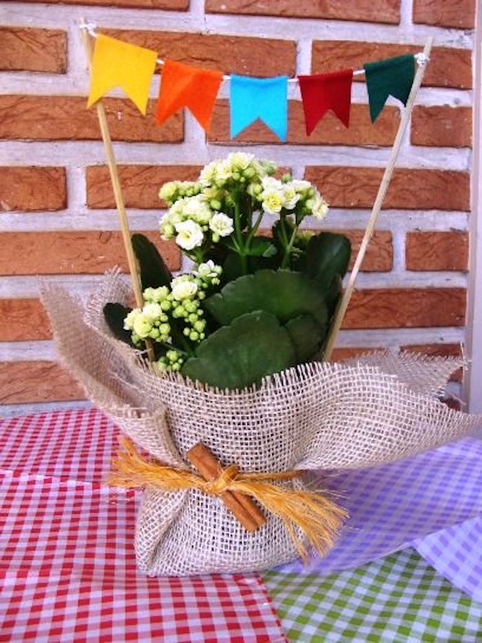 centro de mesa com vaso de flor e bandeirinhas