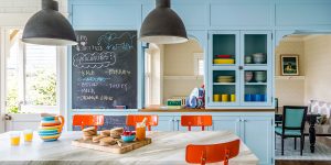 cozinha com armários azuis e banquetas laranjas