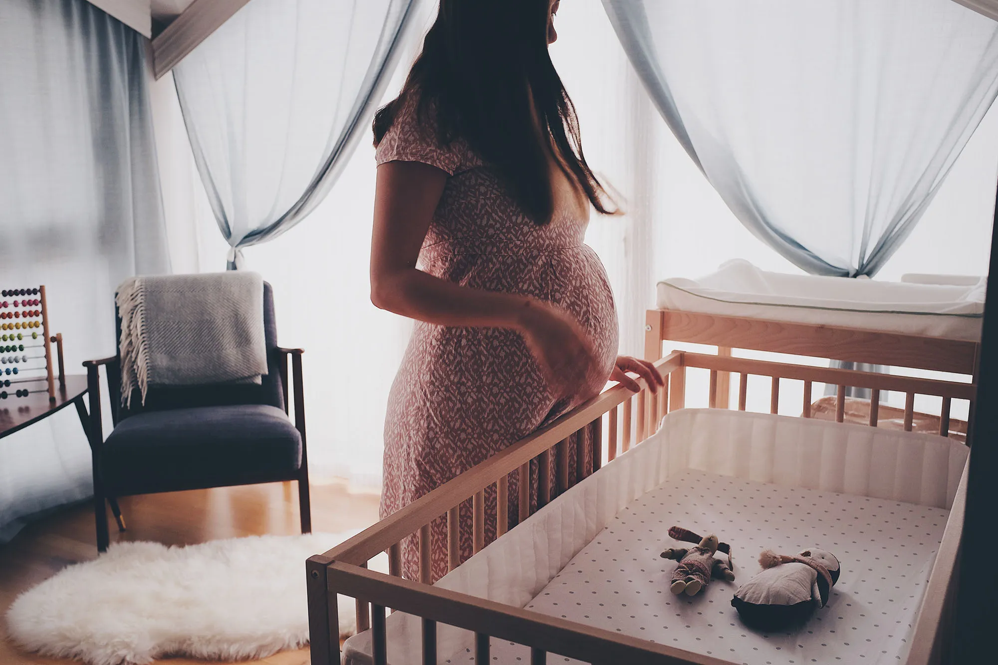 mulher grávida em quarto de bebê