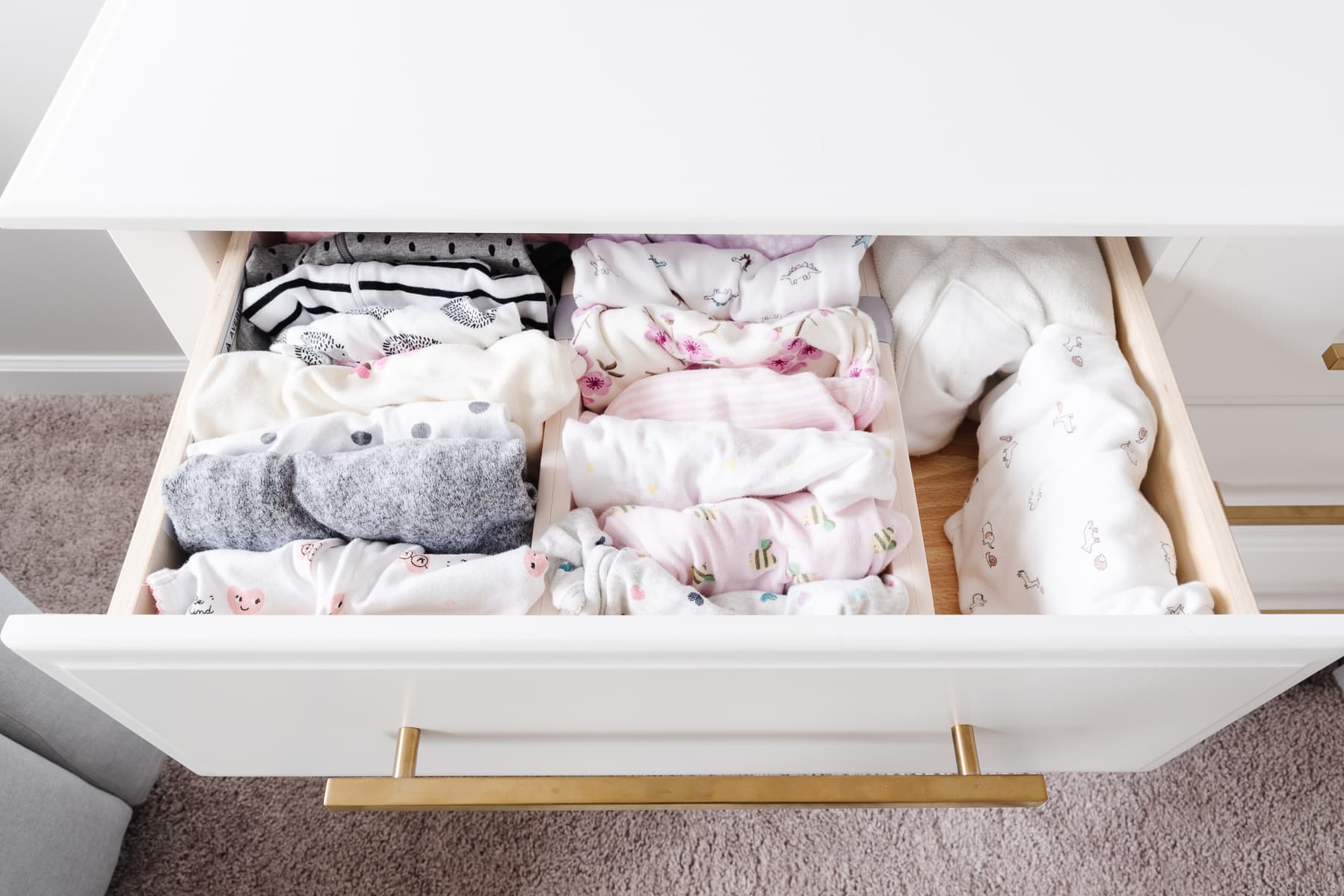 roupas dobradas em cômoda de bebê
