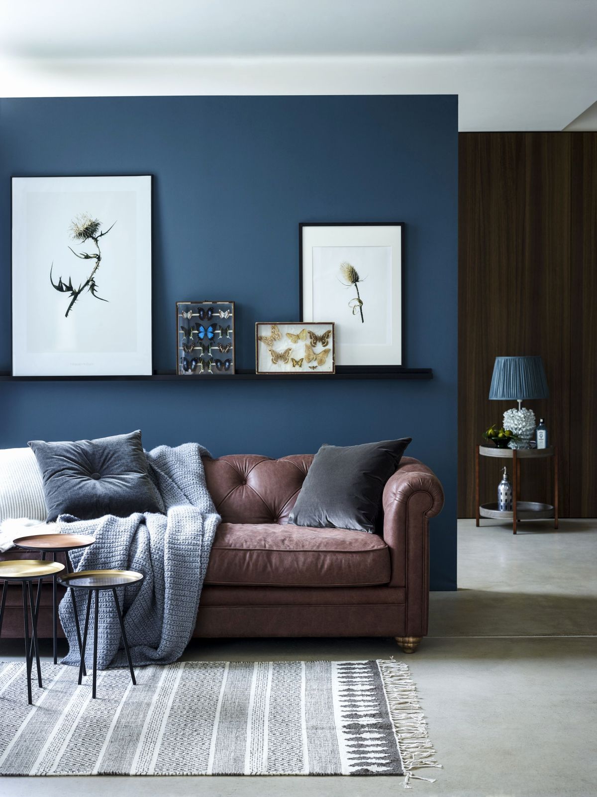 sala com parede azul e sofá marrom
