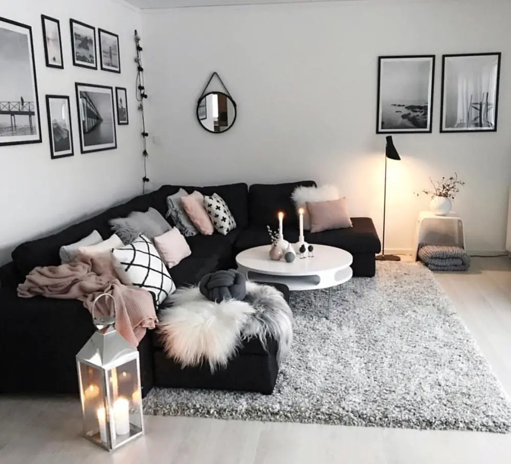 sala com sofá preto e decoração em cinza e branco