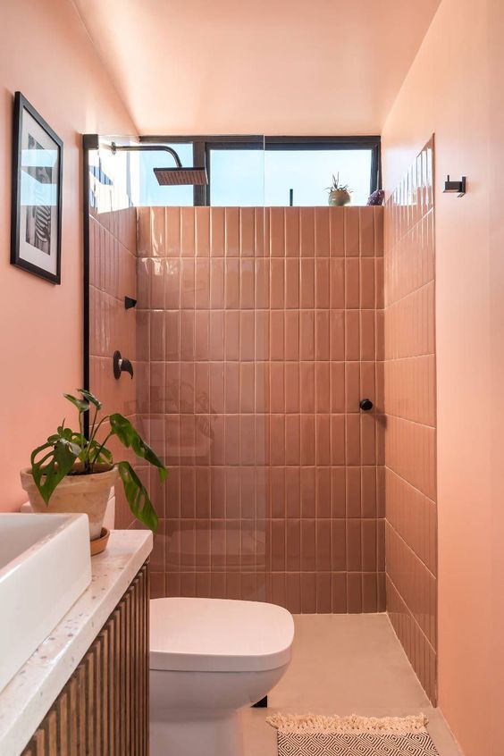 banheiro monocromático com pintura e azulejo rosa