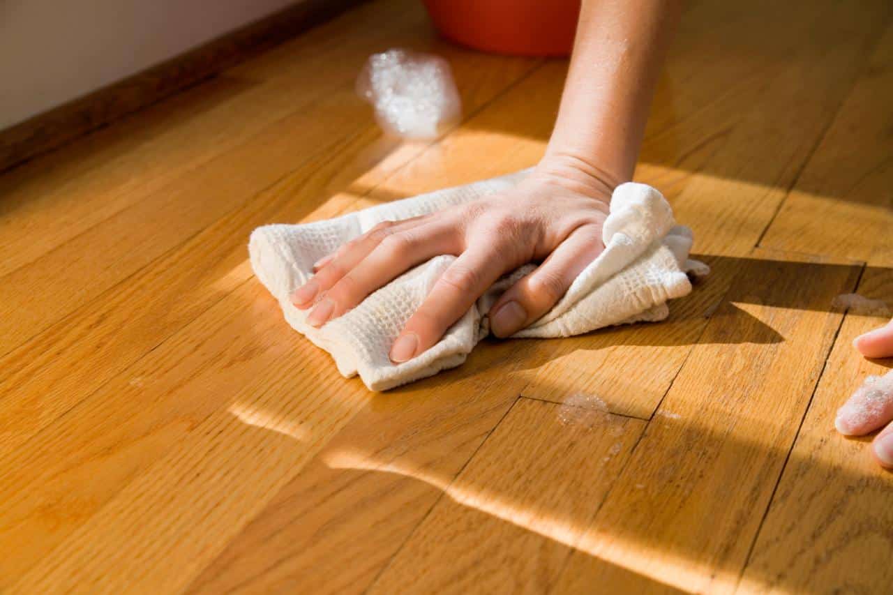 pessoa limpando piso de madeira