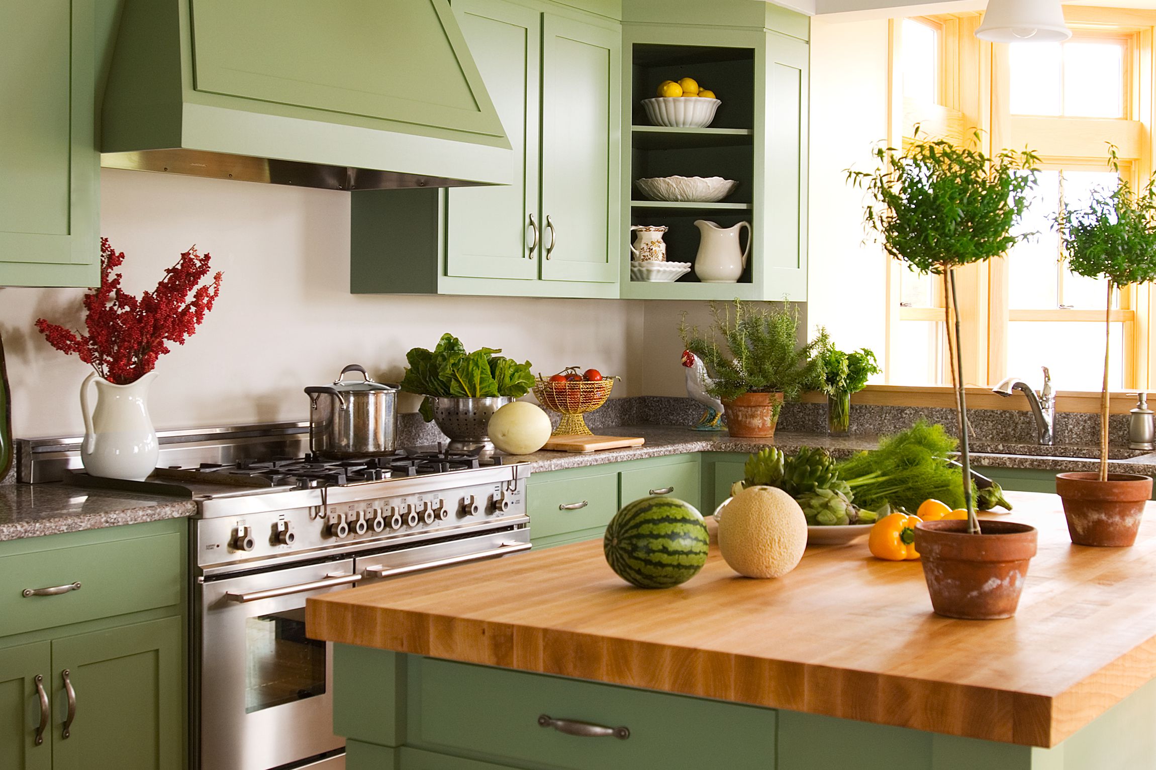 cozinha em tom verde-claro com bancada de madeira