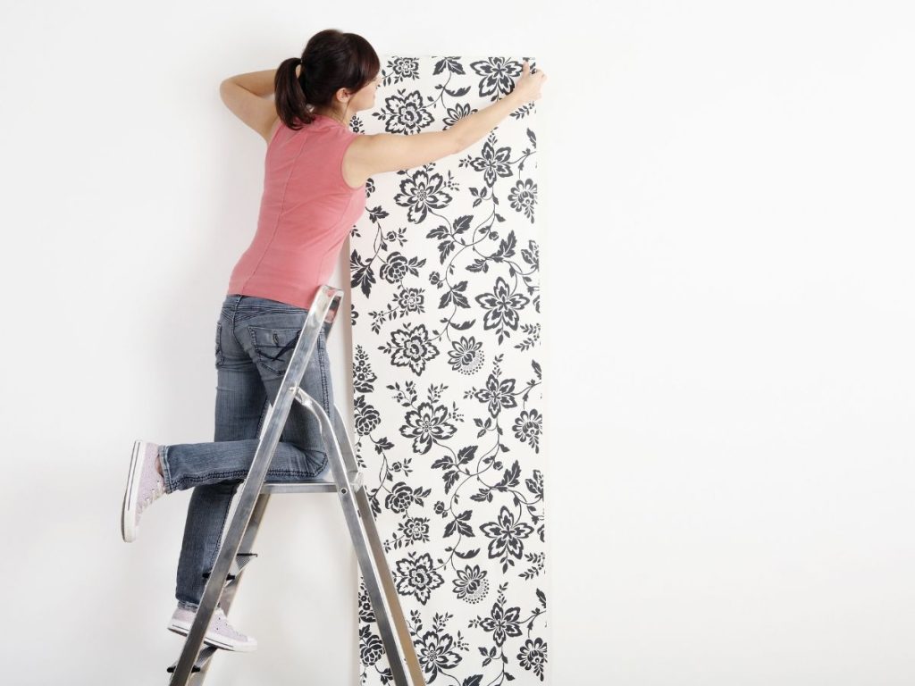 mulher instalando papel de parede