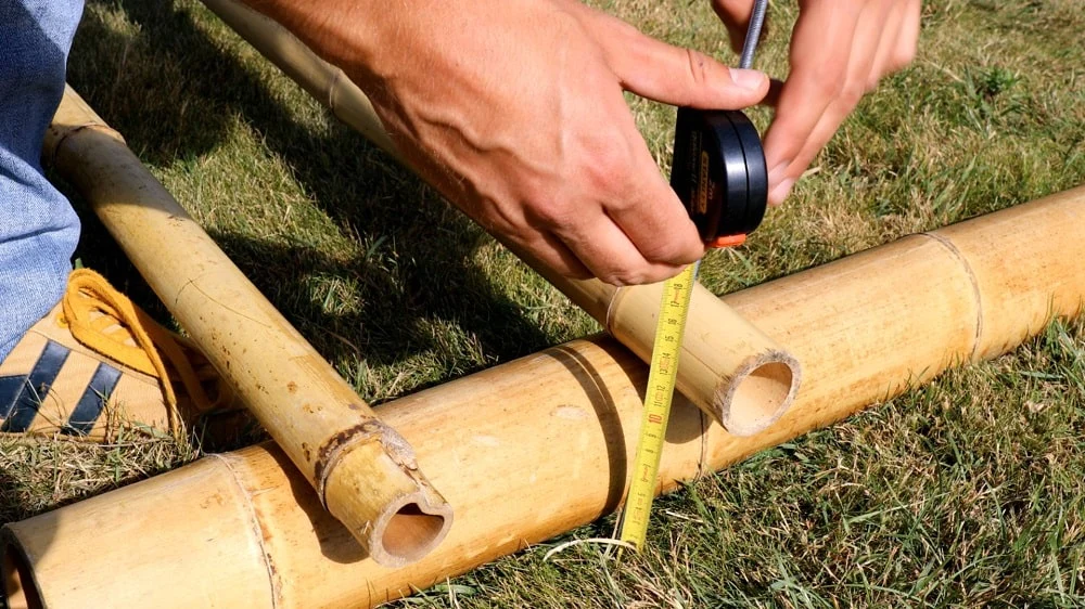 pessoa medindo varas de bambu