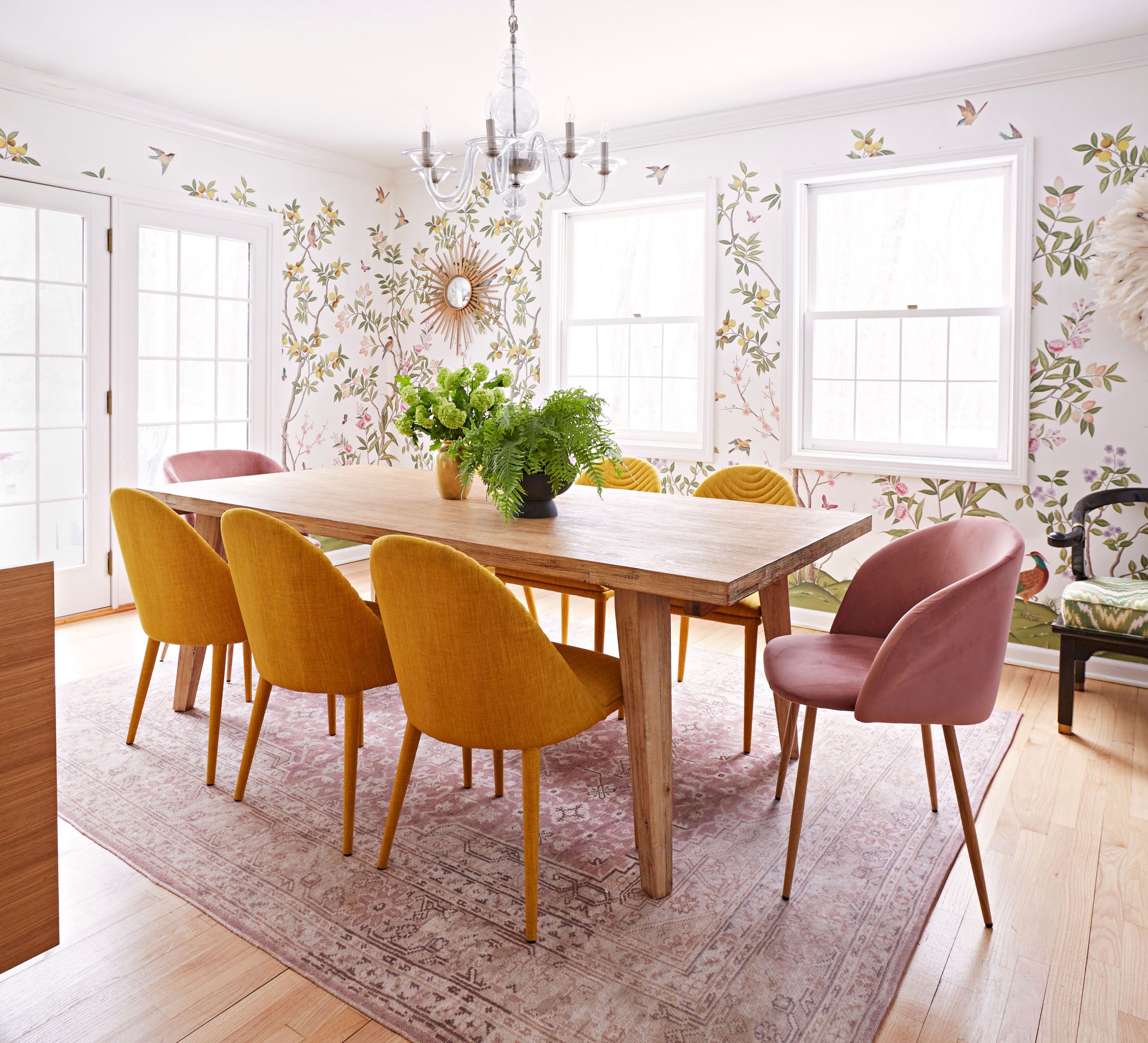 sala de jantar com estampa floral e cadeiras coloridas