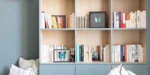 estante de livros azul com nichos de madeira