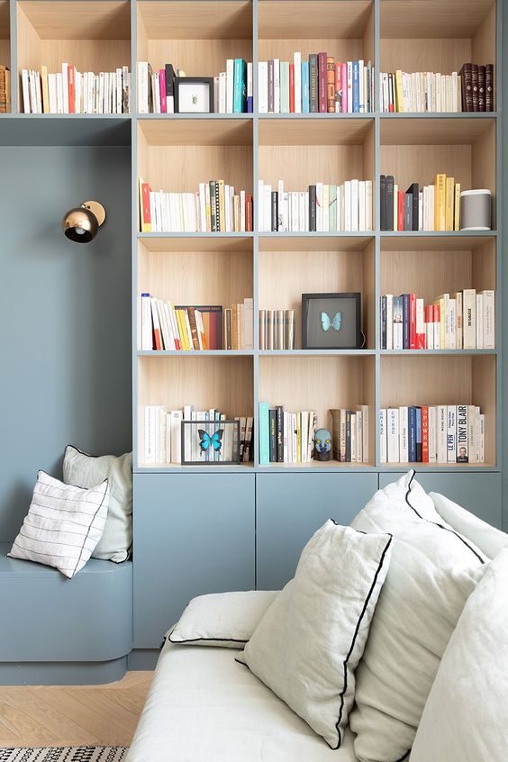 estante de livros azul com nichos de madeira