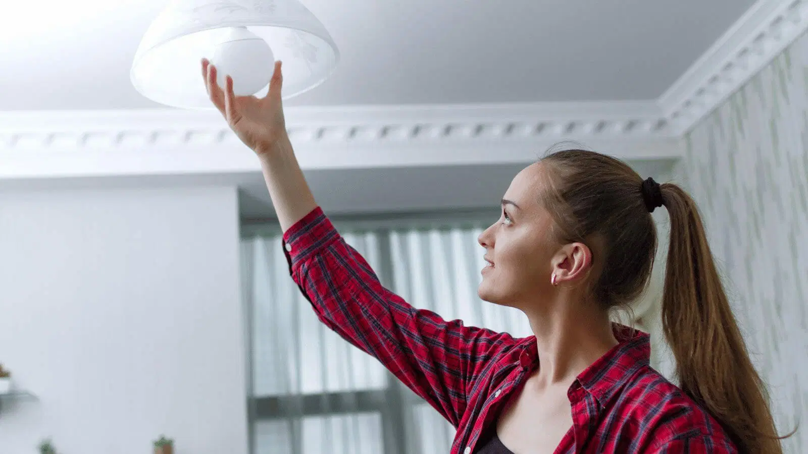 mulher trocando lâmpada de luminária de teto