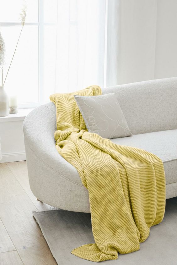 manta amarela para sofa bege curvo
