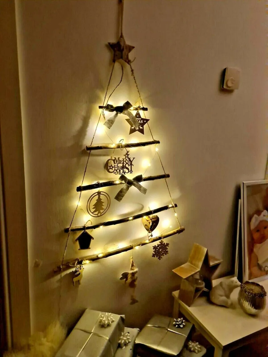 árvore de natal de parede com galhos e luzes