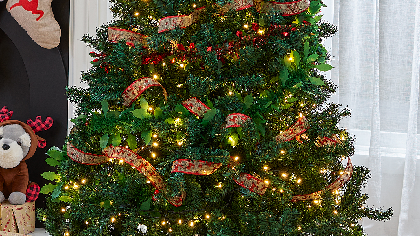 árvore de natal decorada com pisca-pisca e fita