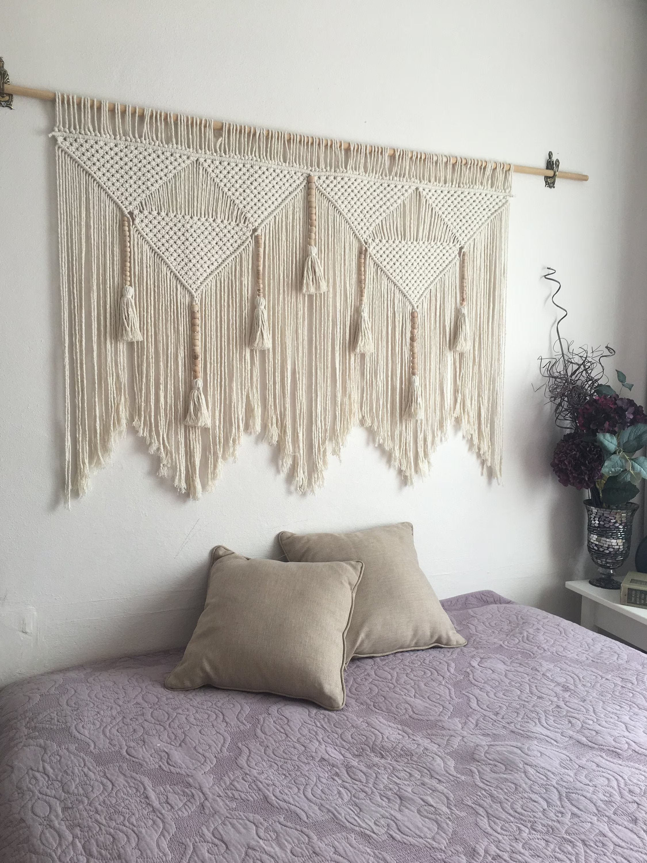 cama com tapeçaria de macramê na parede