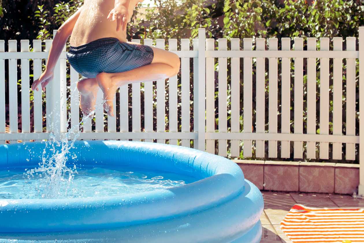 criança pulando de piscina de plástico
