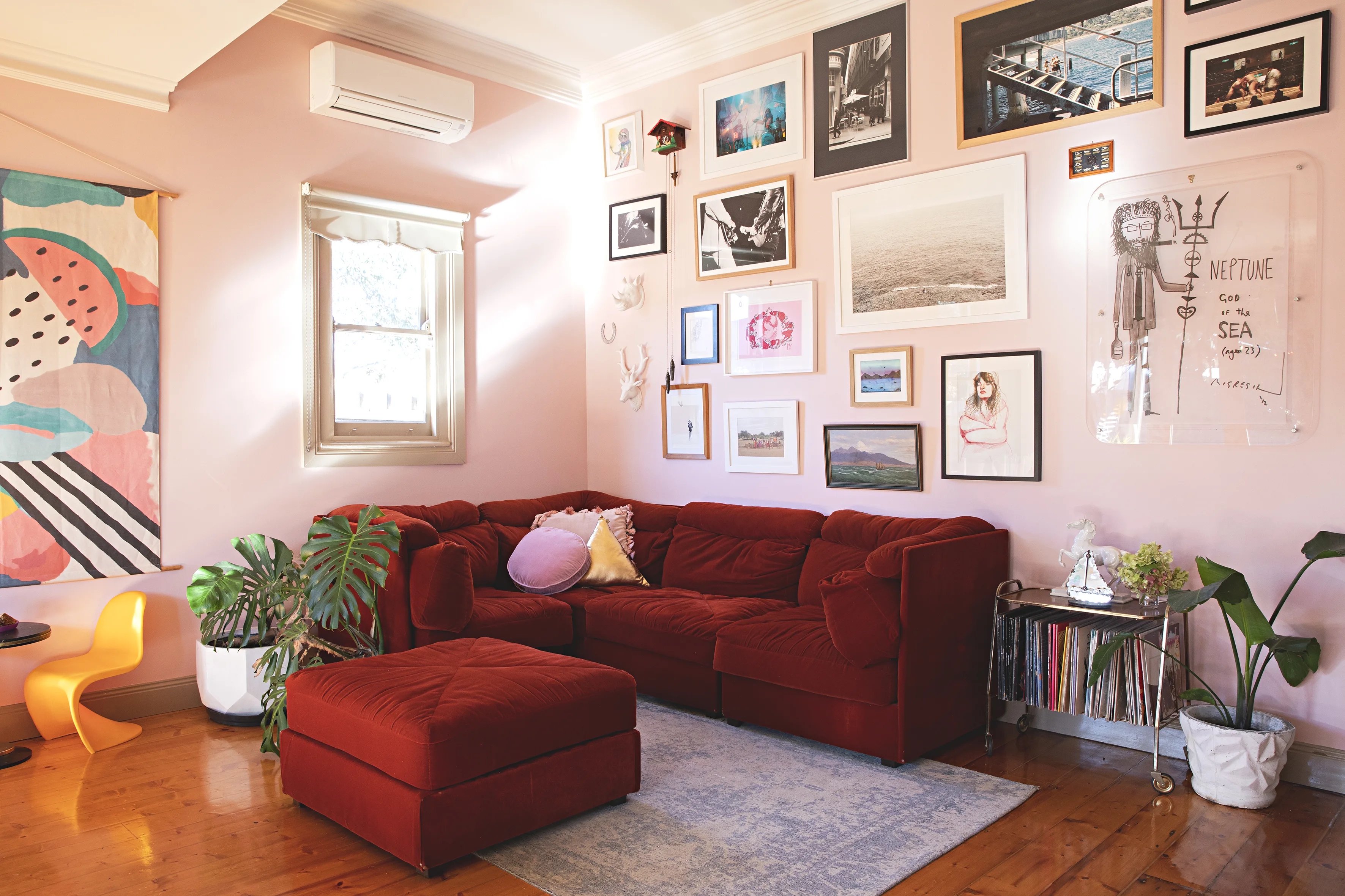 sofá em vermelho-escuro com paredes em rosa-claro