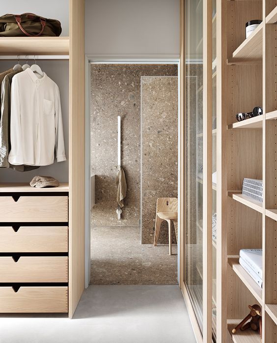 closet em madeira clara com banheiro em pedra