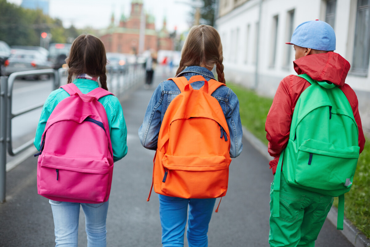 crianças com mochilas coloridas nas costas
