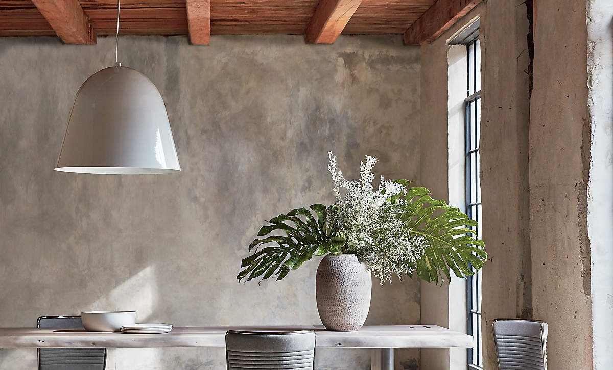 sala de jantar com parede irregular e vaso de planta sobre a mesa